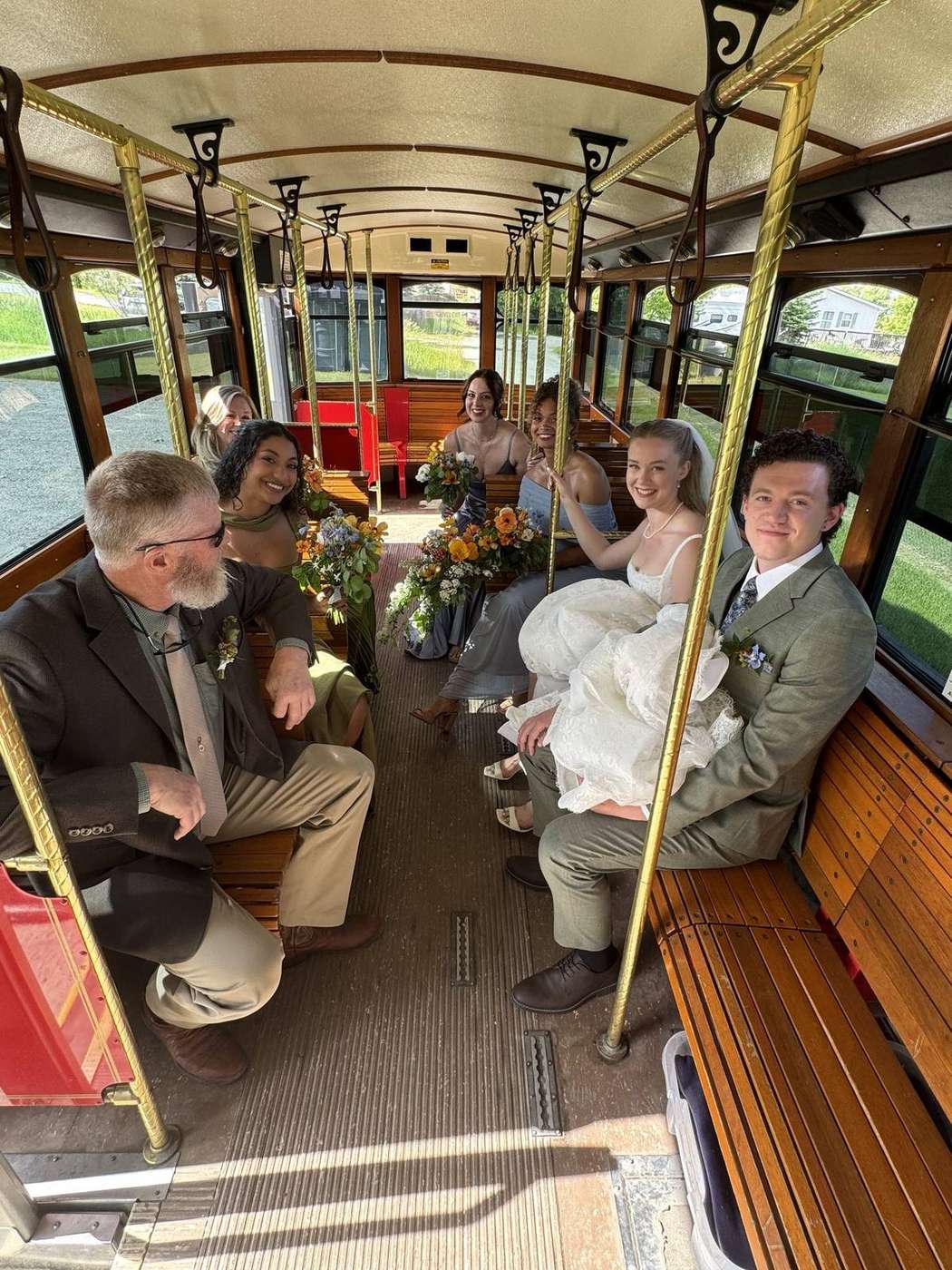 Guests seated inside a Montana trolley on oak benches with brass rails