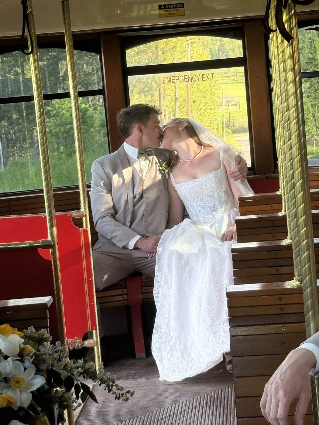 Bride and groom sharing a kiss on trolley benches
