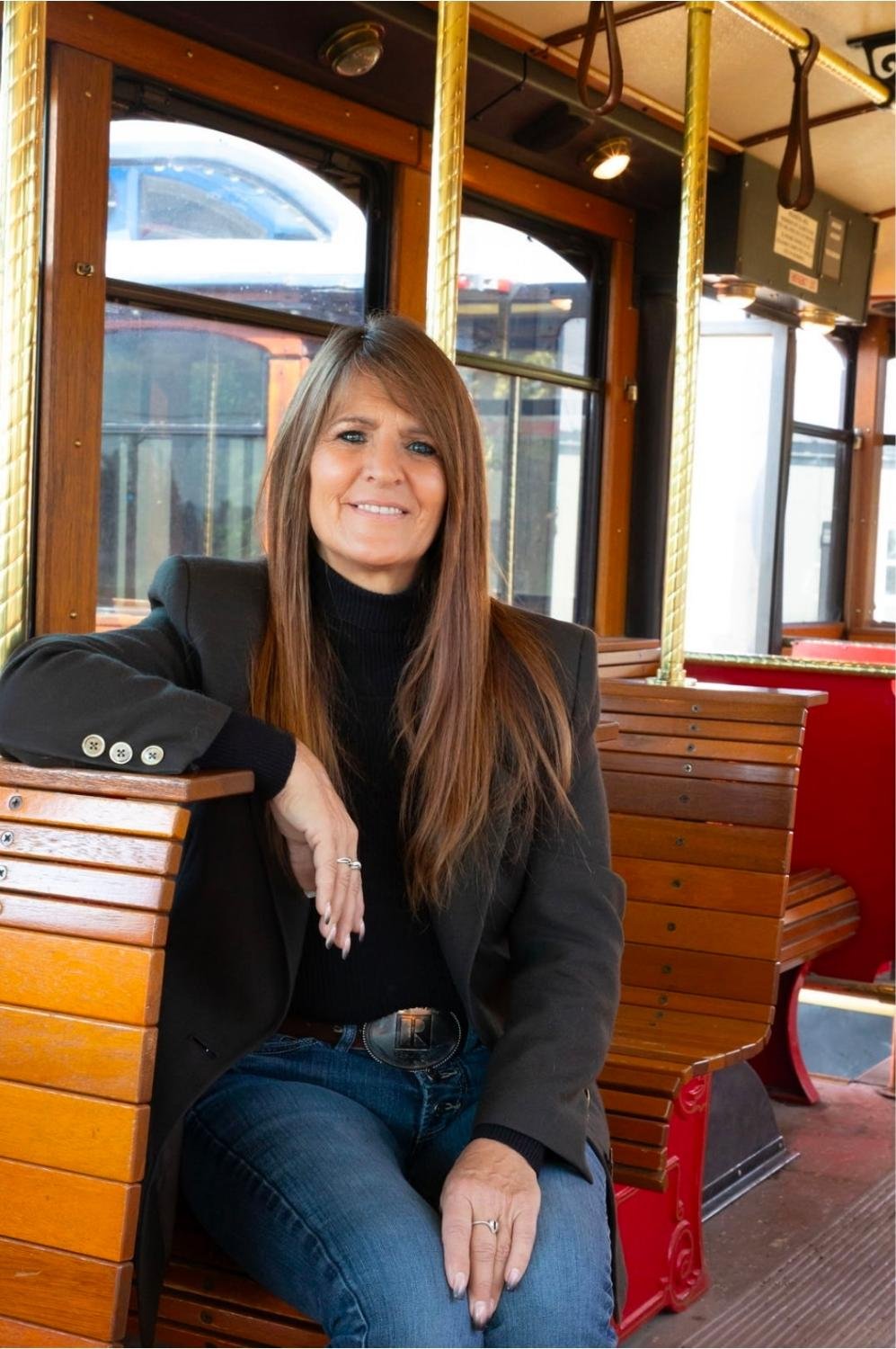 Jodie Cross, owner of Montana Trolley Company, seated aboard a classic trolley